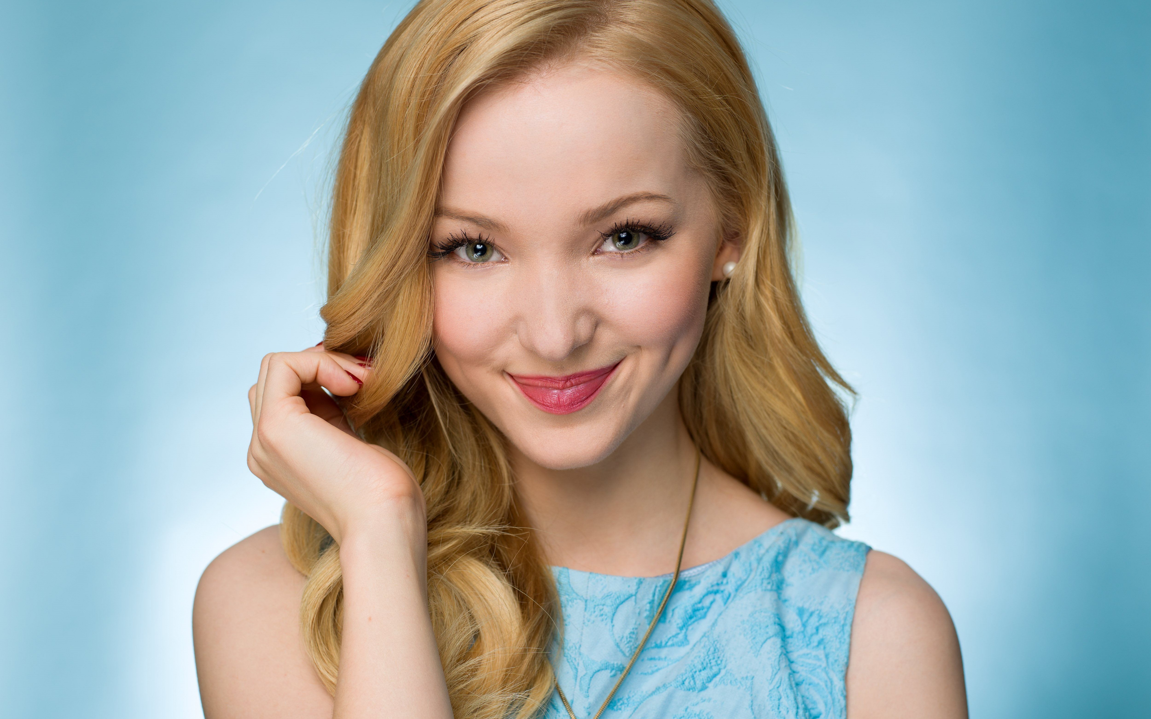 Wallpaper Smiling beautiful girl actress Dove Cameron on a blue background.