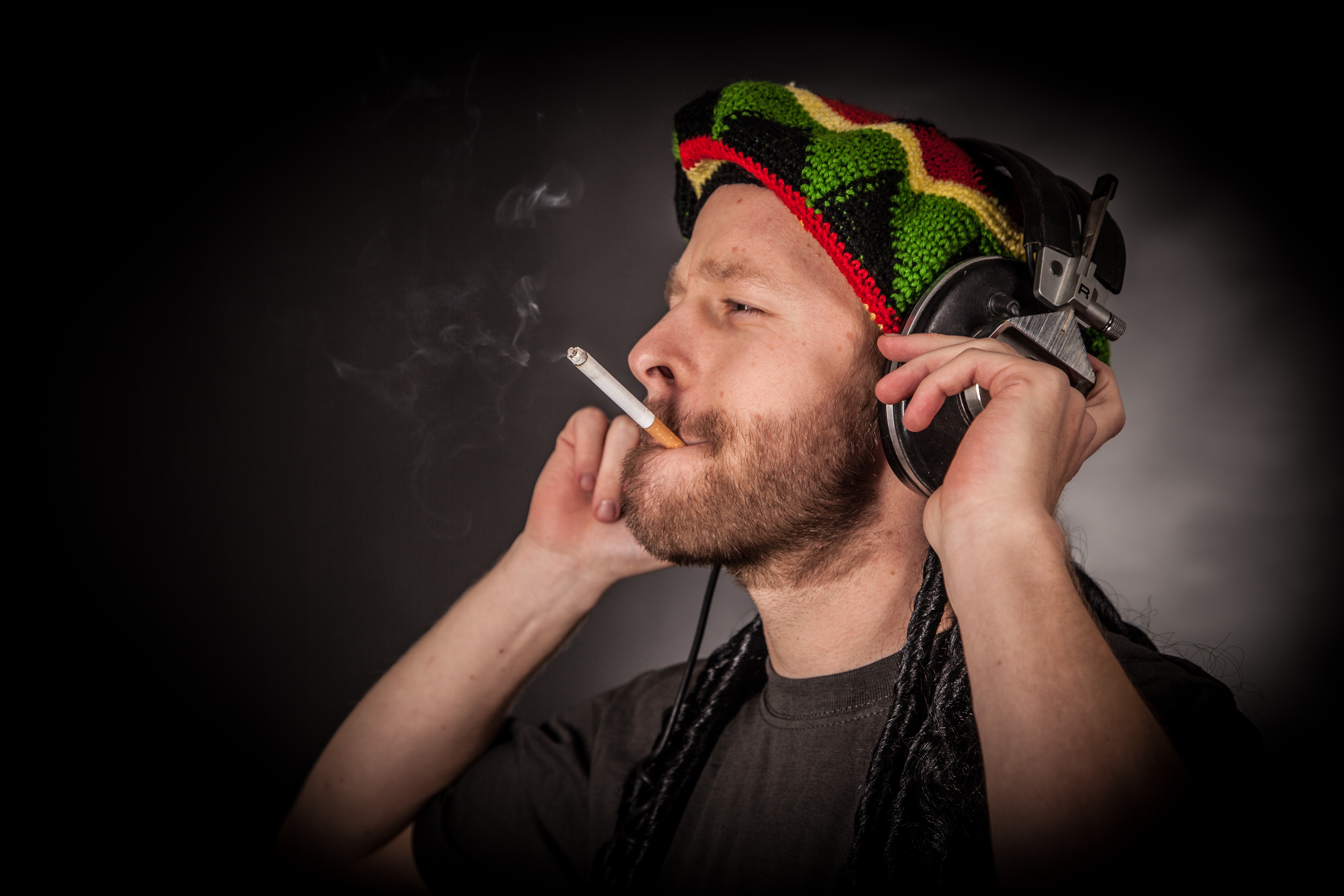 Wallpaper Rasta man in headphones with a cigarette.