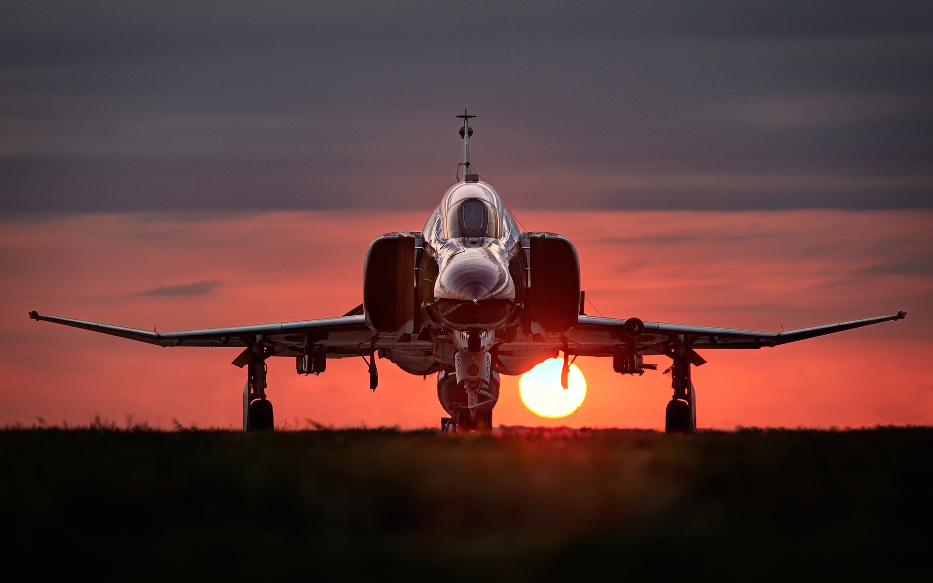Обои Истребитель F-4 Phantom II стоит на фоне заката.